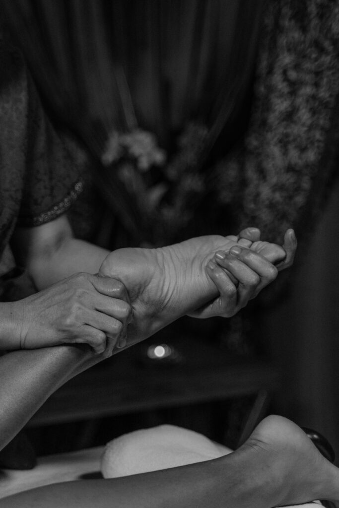 Gros plan artistique en noir et blanc d'un massage thérapeutique des pieds, illustrant le talent et le savoir-faire des professionnels de santé accompagnés par DigiSphere 84.